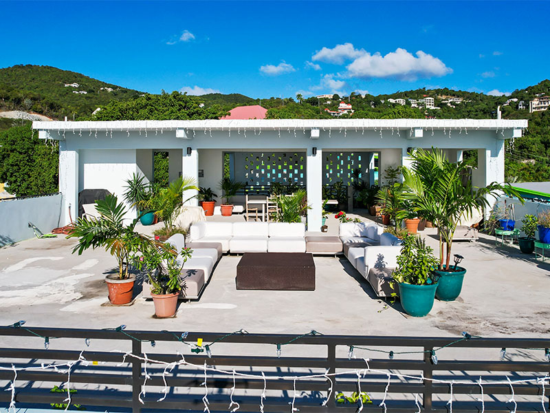 Modern rooftop entertainment area with tropical plants
