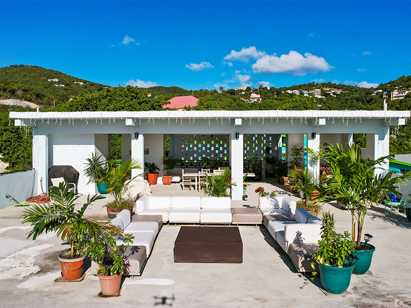 Luxurious rooftop lounge with modern white furniture and pergola