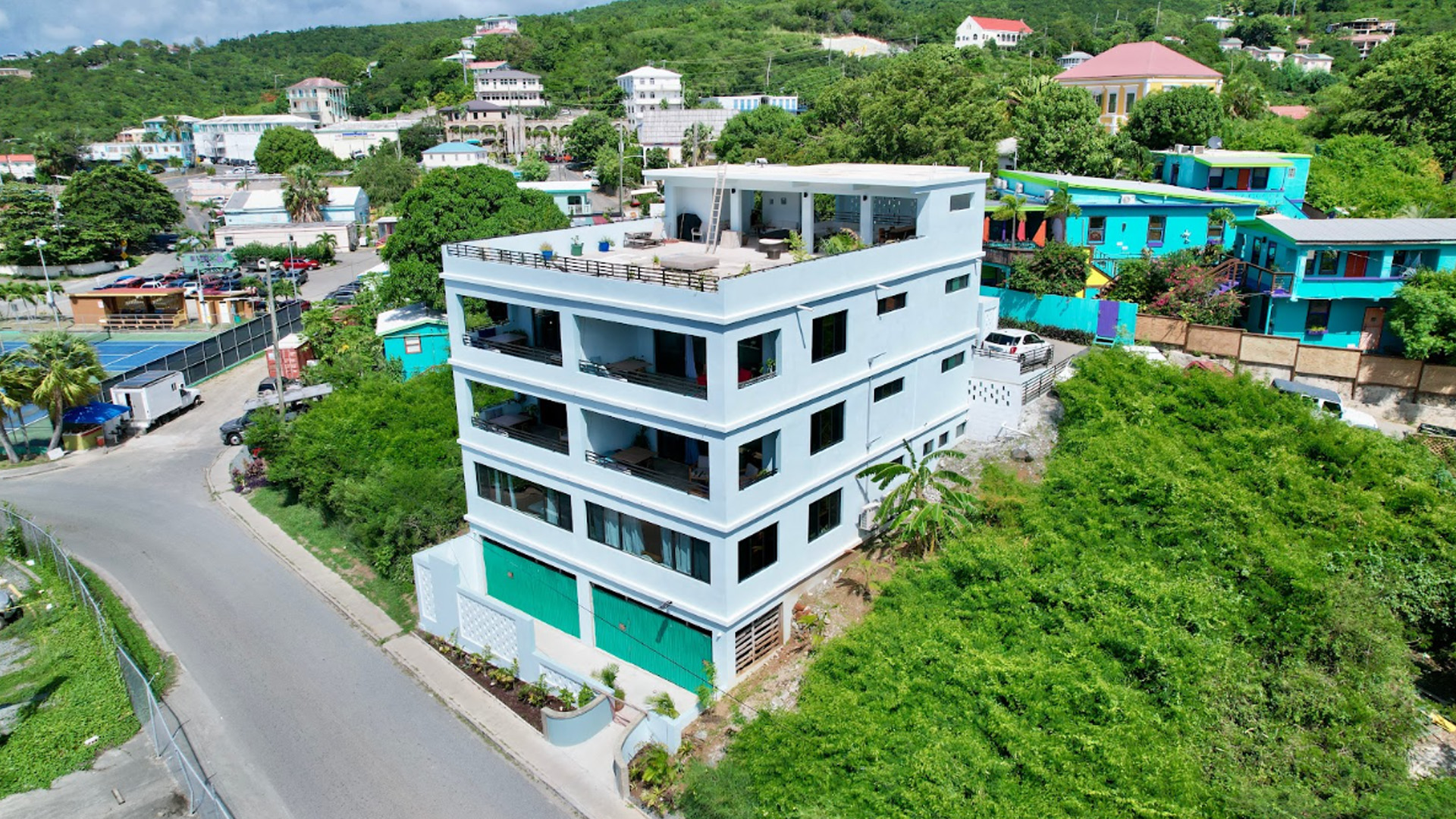 Aerial view of THE ALMA - ST JOHN building showing rooftop terrace and surrounding neighborhood