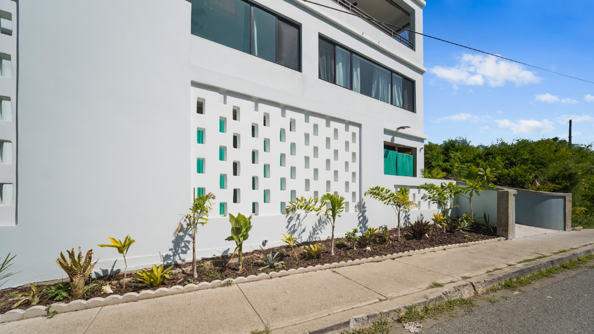 THE ALMA - ST JOHN exterior facade with decorative teal window pattern